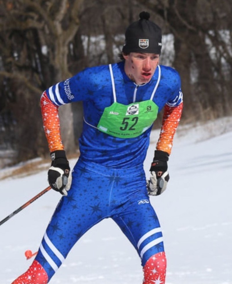 Freestyle nordic skier racing in a green 360 Race Bib number 52 on course